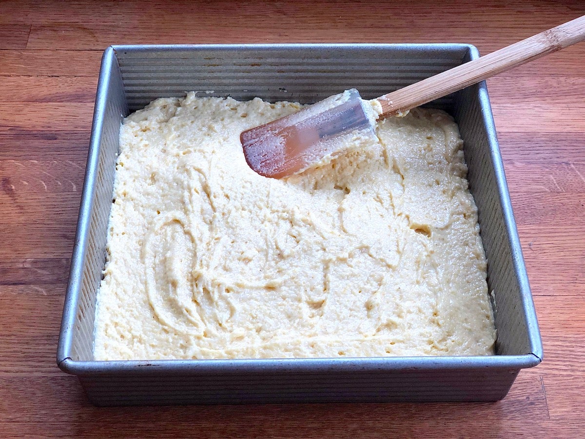 Cornbread batter spread in a 9" square pan ready to be baked