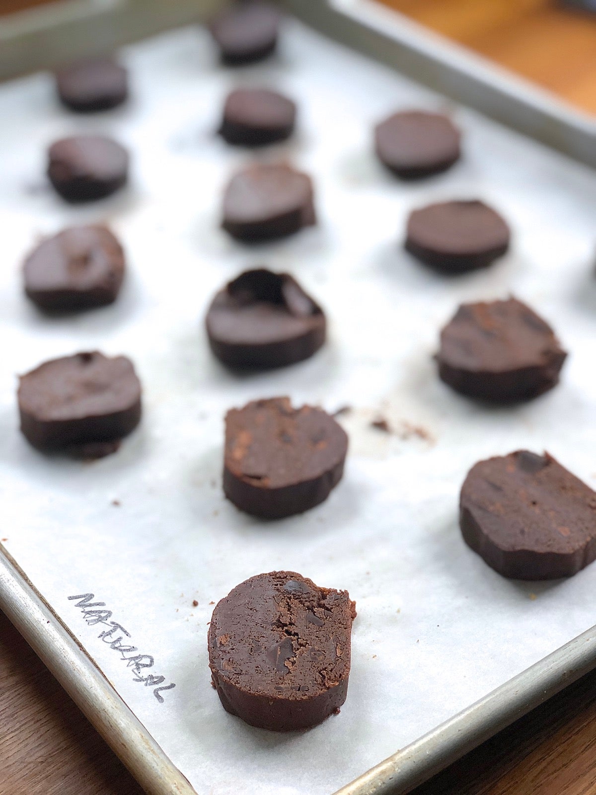 Chocolate cookie dough slices on a baking sheet, ready to bake.