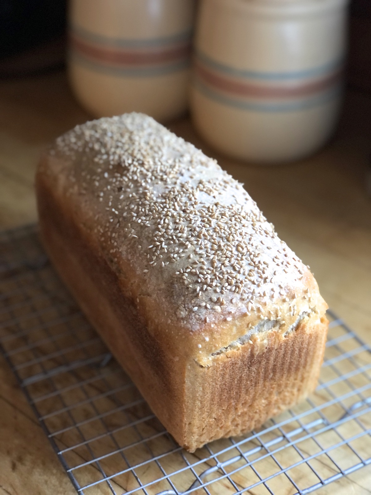 Loaf of sourdough bread on a cooling rack.