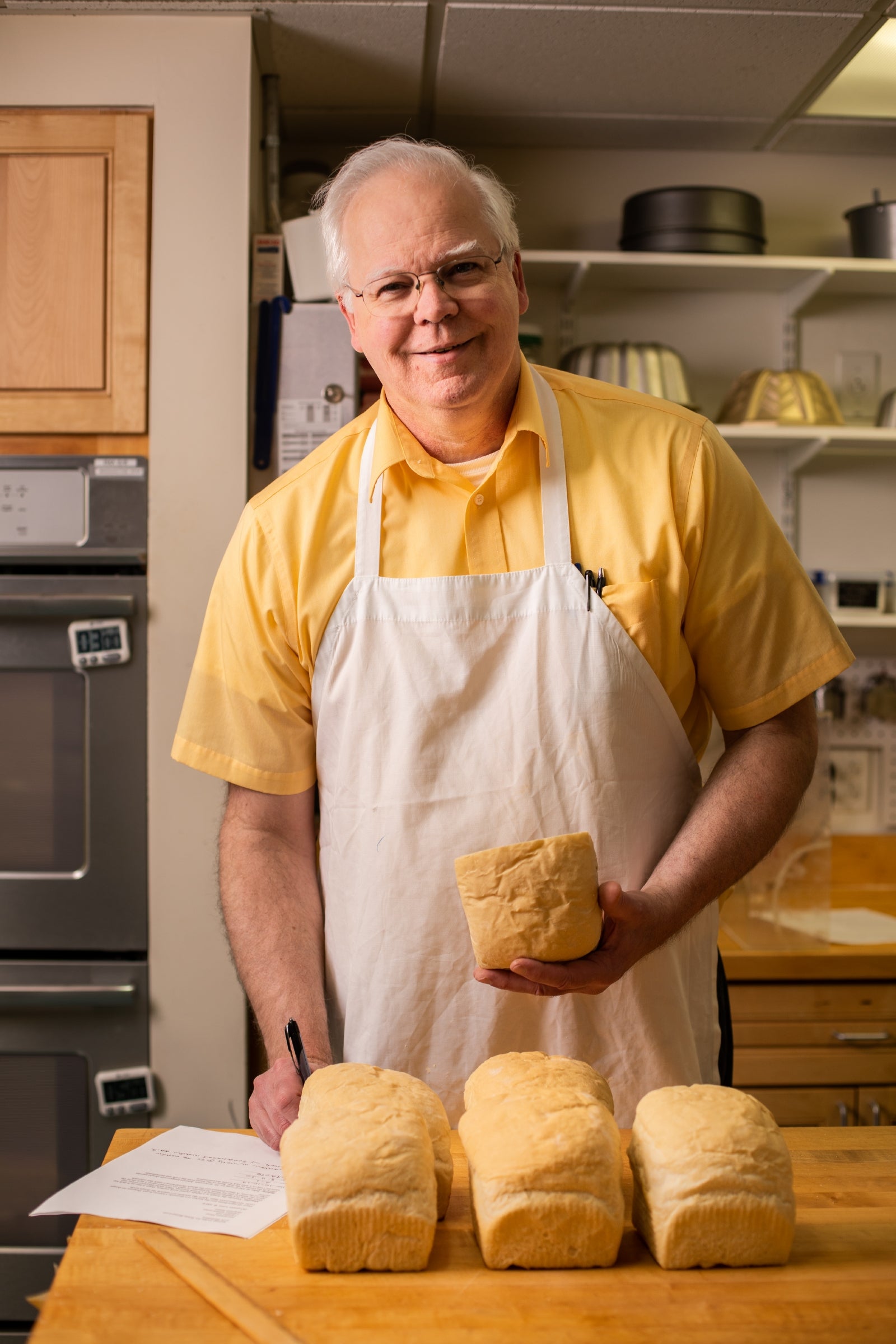 Frank smiles for the camera while taking notes on his latest bake test