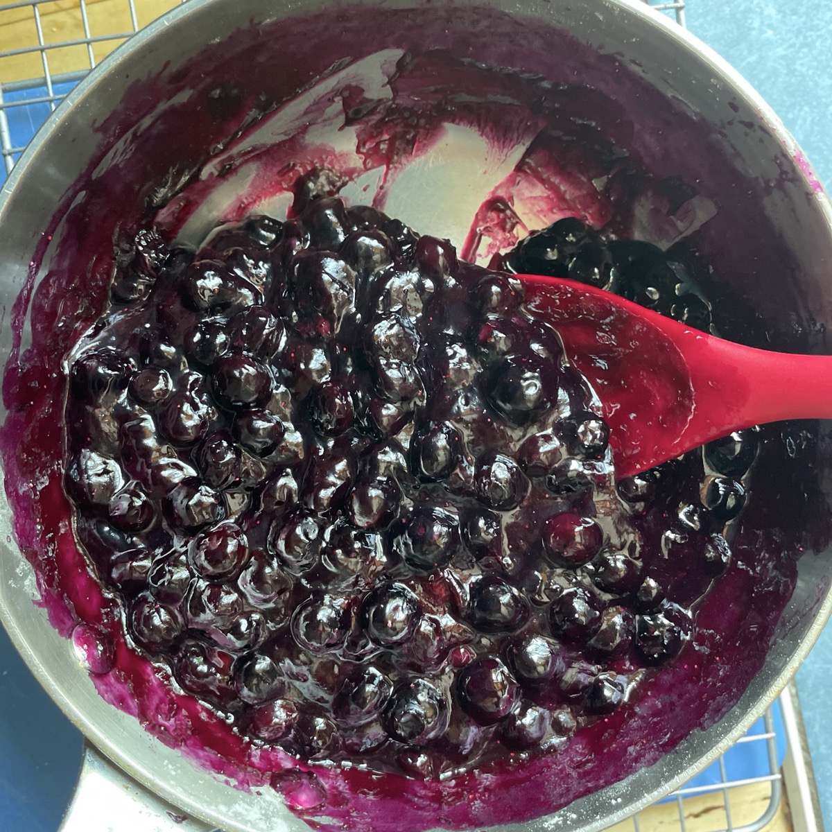 Fresh blueberries simmered in a saucepan with water, cornstarch, and sugar.