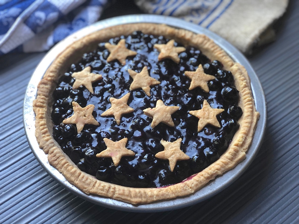 Open-face blueberry pie with baked star cutouts decorating the top.