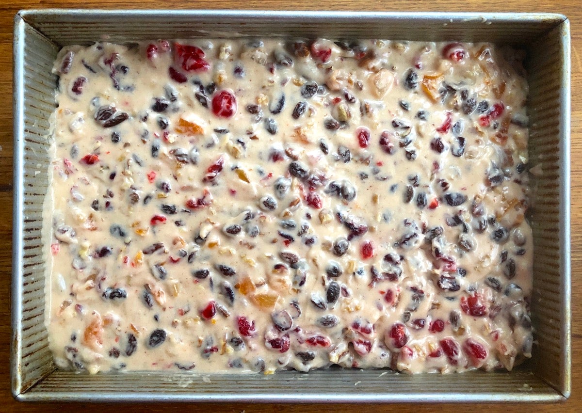 Light-colored fruitcake batter poured into a 9" x 13" pan.