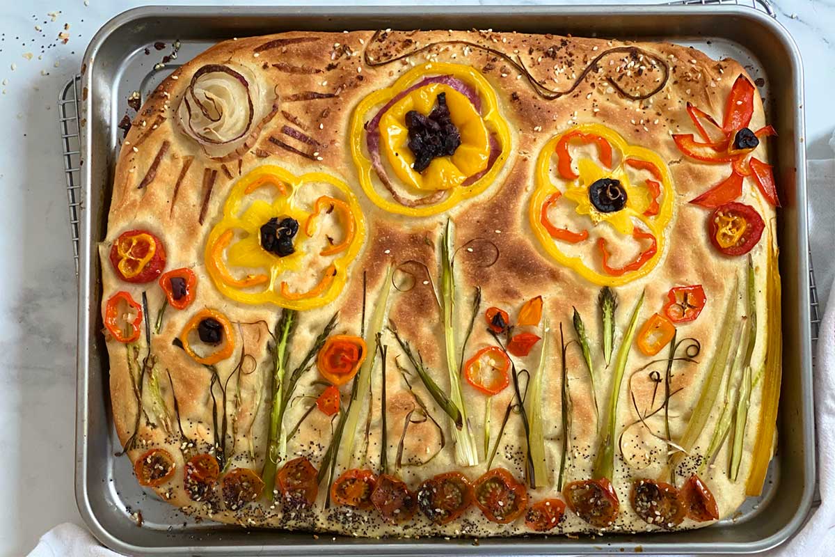 A baked garden focaccia on a cooling rack