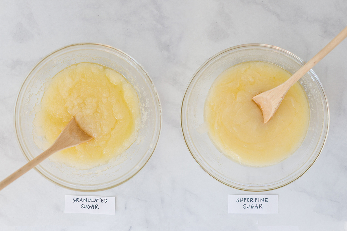 A bowl of melted butter and superfine sugar next to a bowl of melted butter and granulated sugar