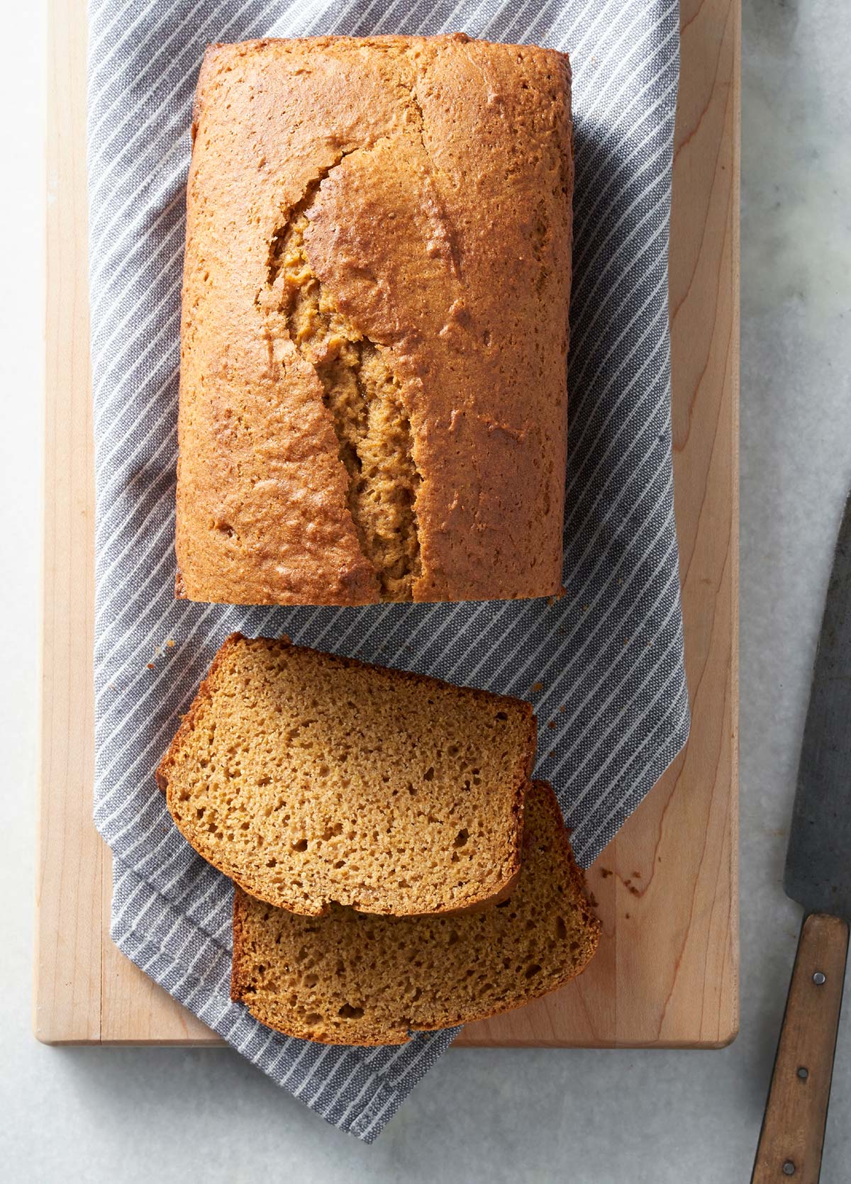 A loaf of Gluten-Free Pumpkin Bread with a few slices