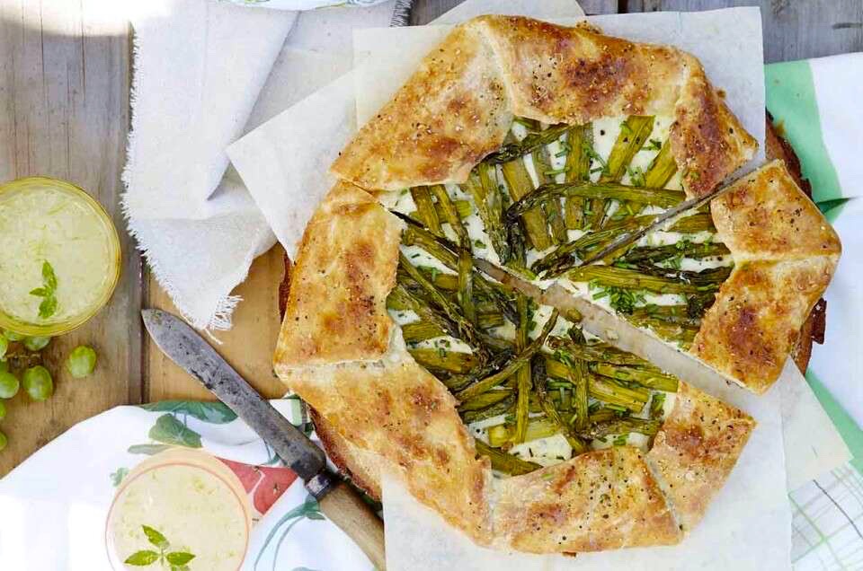 Asparagus and chive galette on a table, ready to be cut.