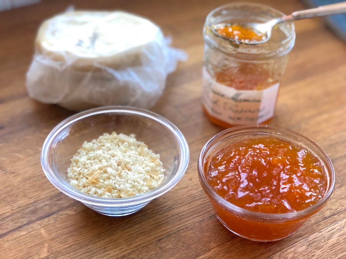 A bowl of bred crumbs and a bowl of apricot preserves ready to be stirred together to make apricot filling.