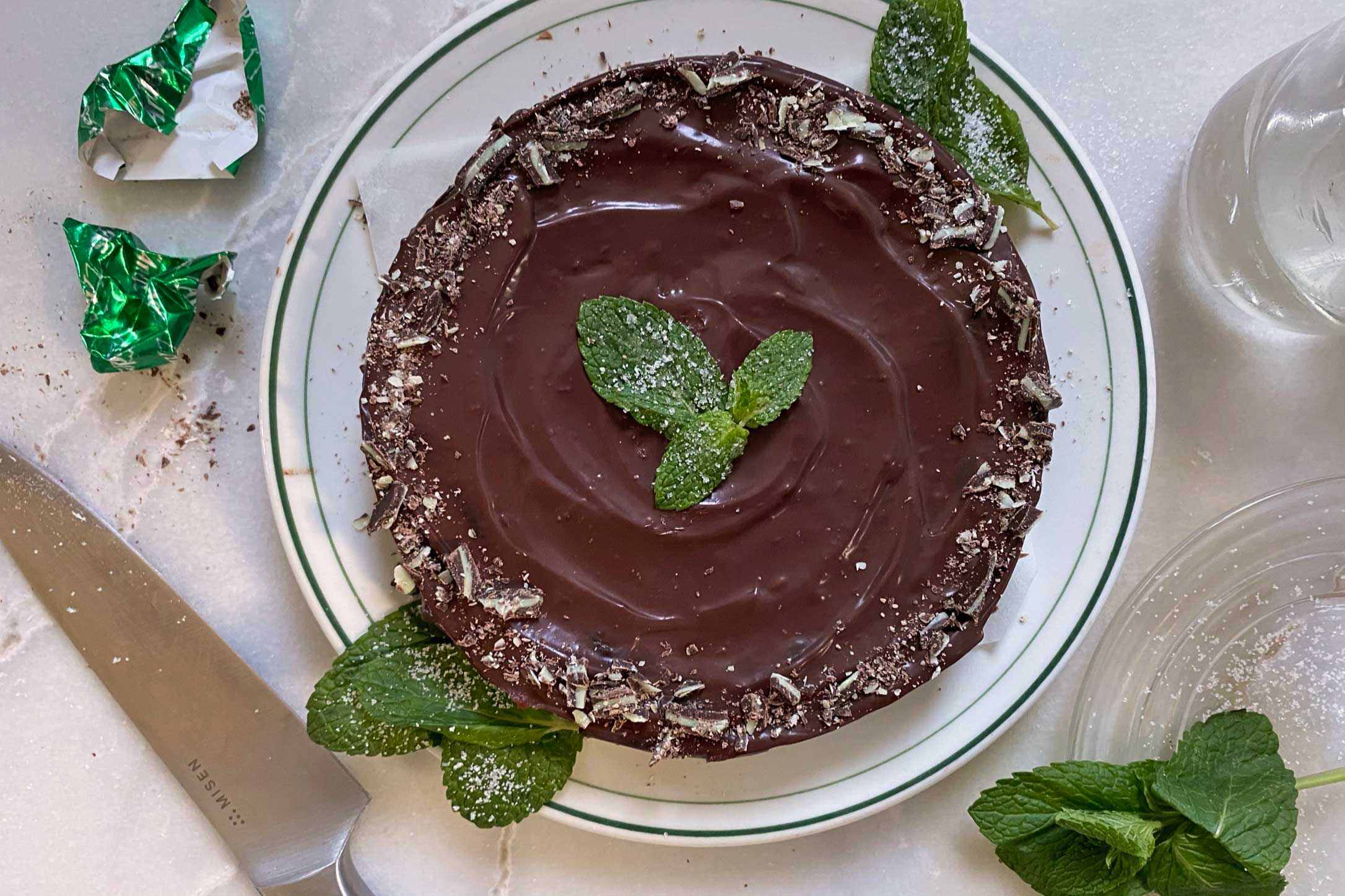 A flourless chocolate cake decorated with sugar mint leaves and chopped mint candies