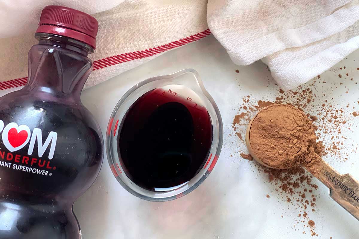 Burgundy cocoa next to a bottle of pomegranite juice