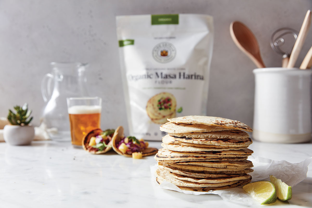 Stack of tortillas with bag of masa harina in background