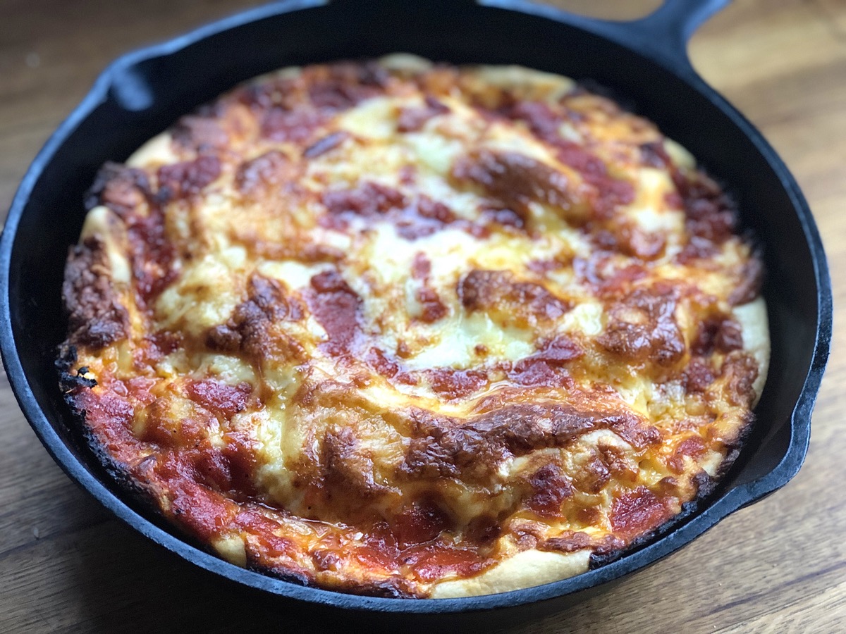 Crispy Cheesy Pan Pizza in a cast iron skillet, hot from the oven