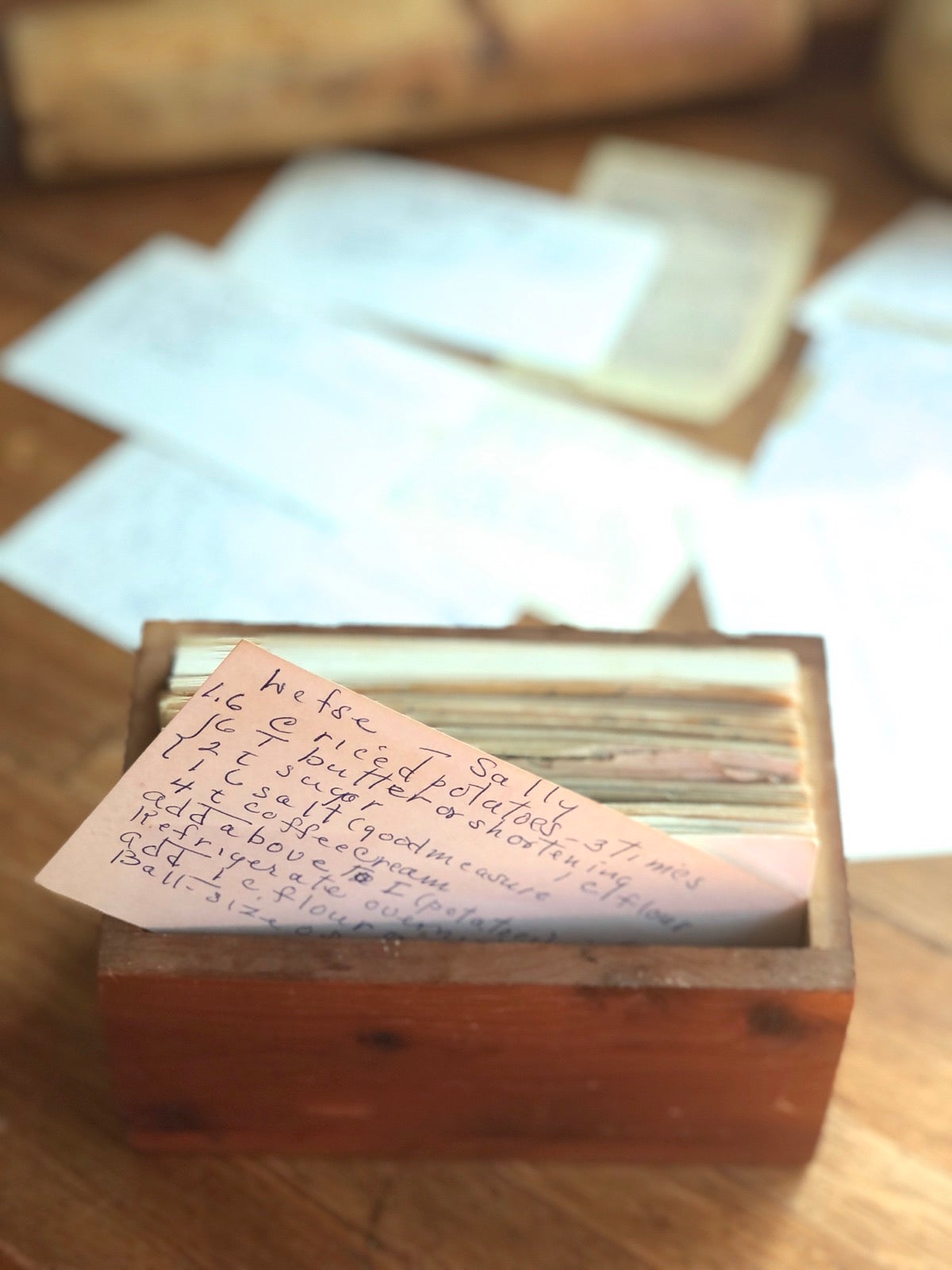 Old wooden recipe box with a lefse recipe card half pulled out.