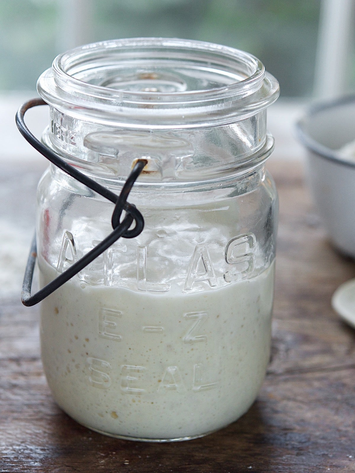 Mason jar of sourdough starter on the counter.