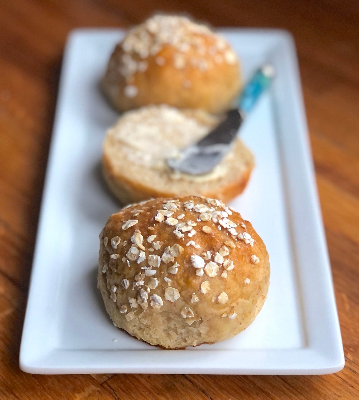 Whole grain dinner rolls on a plate.