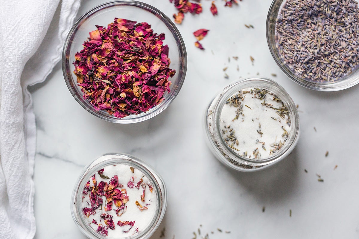 Rose petals on a plate next to a bowl of lavender flowers, ready to make infused sugar