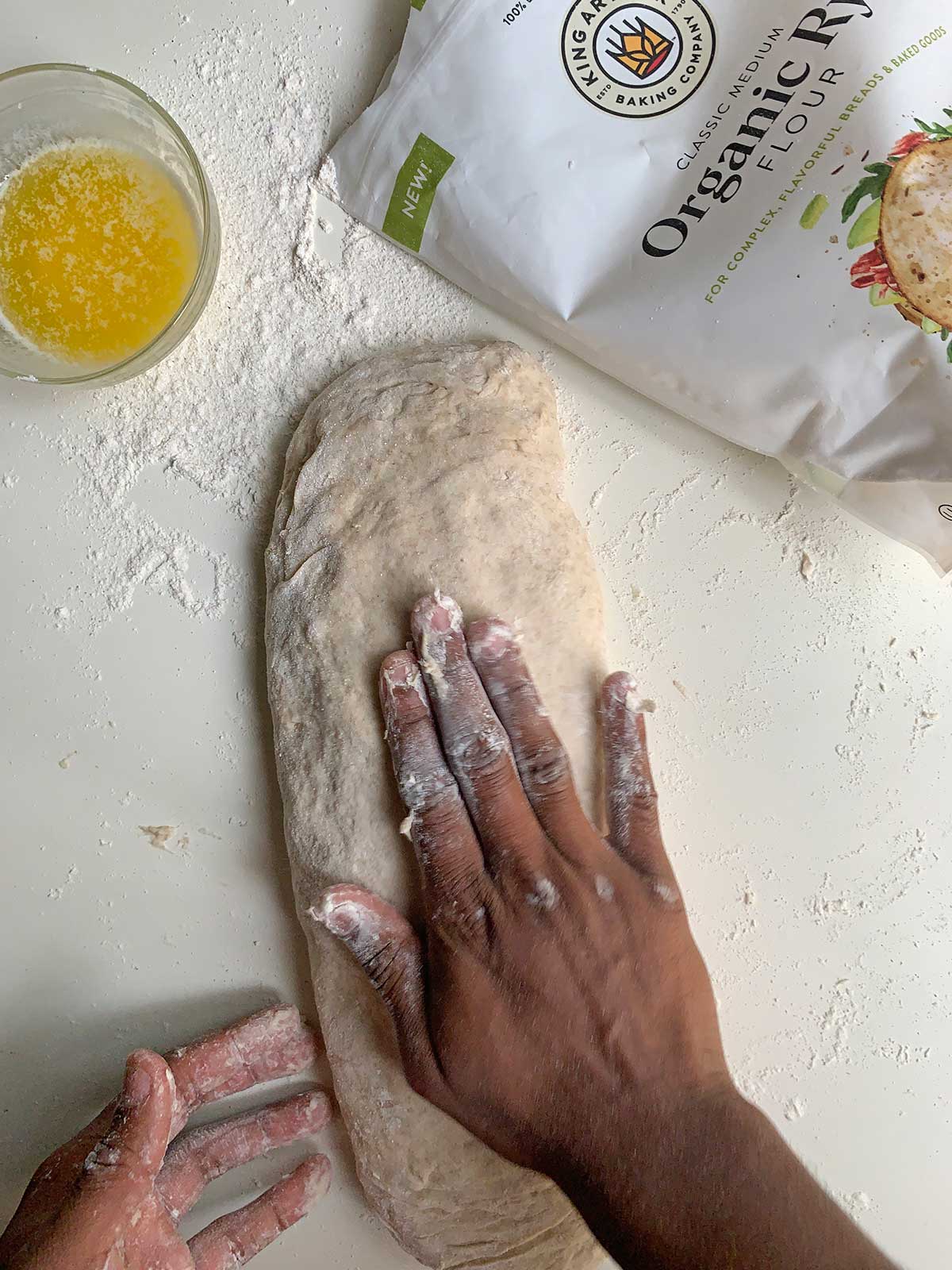 Hands shaping the focaccia dough