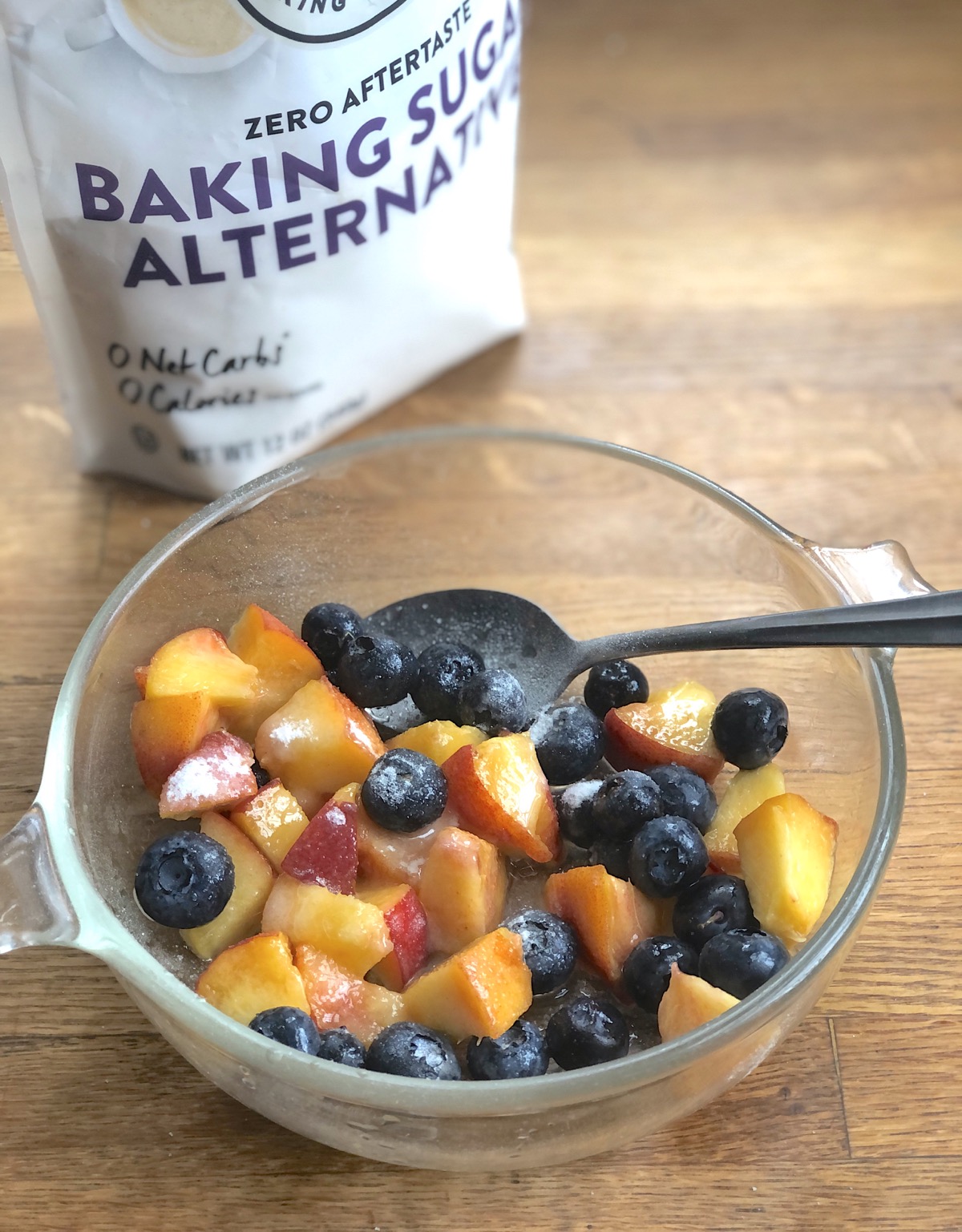Fresh blueberries and diced peaches in a bowl with Baking Sugar Alternative sprinkled on top, to sweeten.