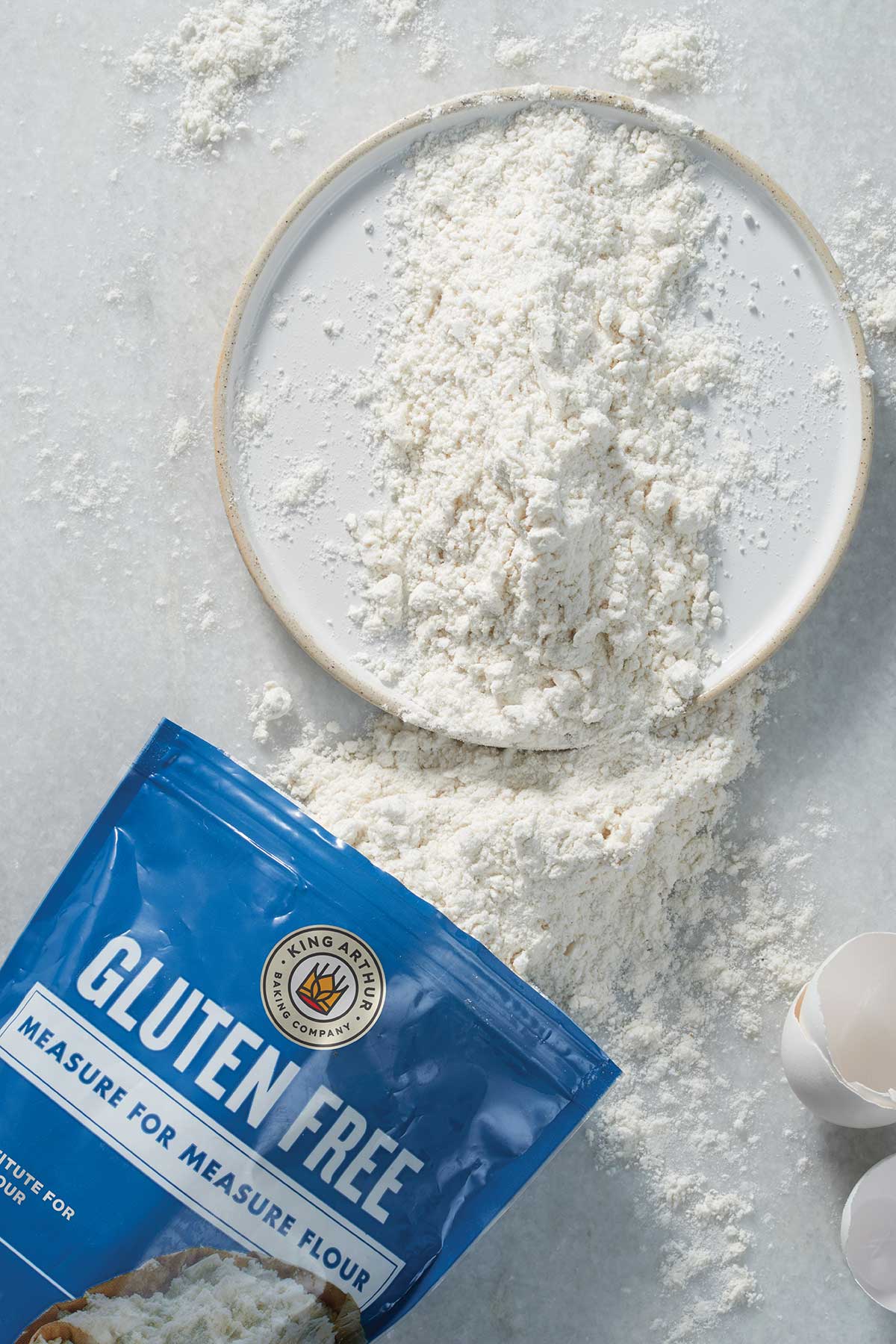 A bag of King Arthur Gluten-Free Measure for Measure Flour spilling out onto a kitchen table