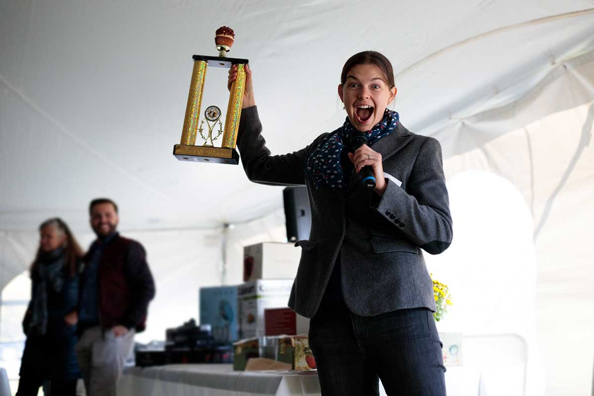 A baker receiving a trophy with a cupcake on top