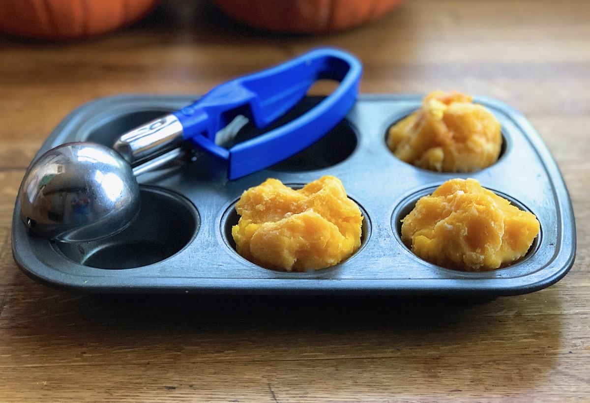 Pumpkin purée spooned into the wells of a muffin pan prior to freezing