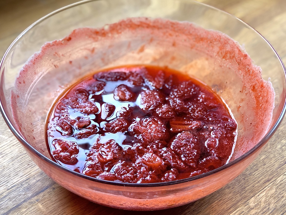Bowl of partially cooked strawberry preserves.