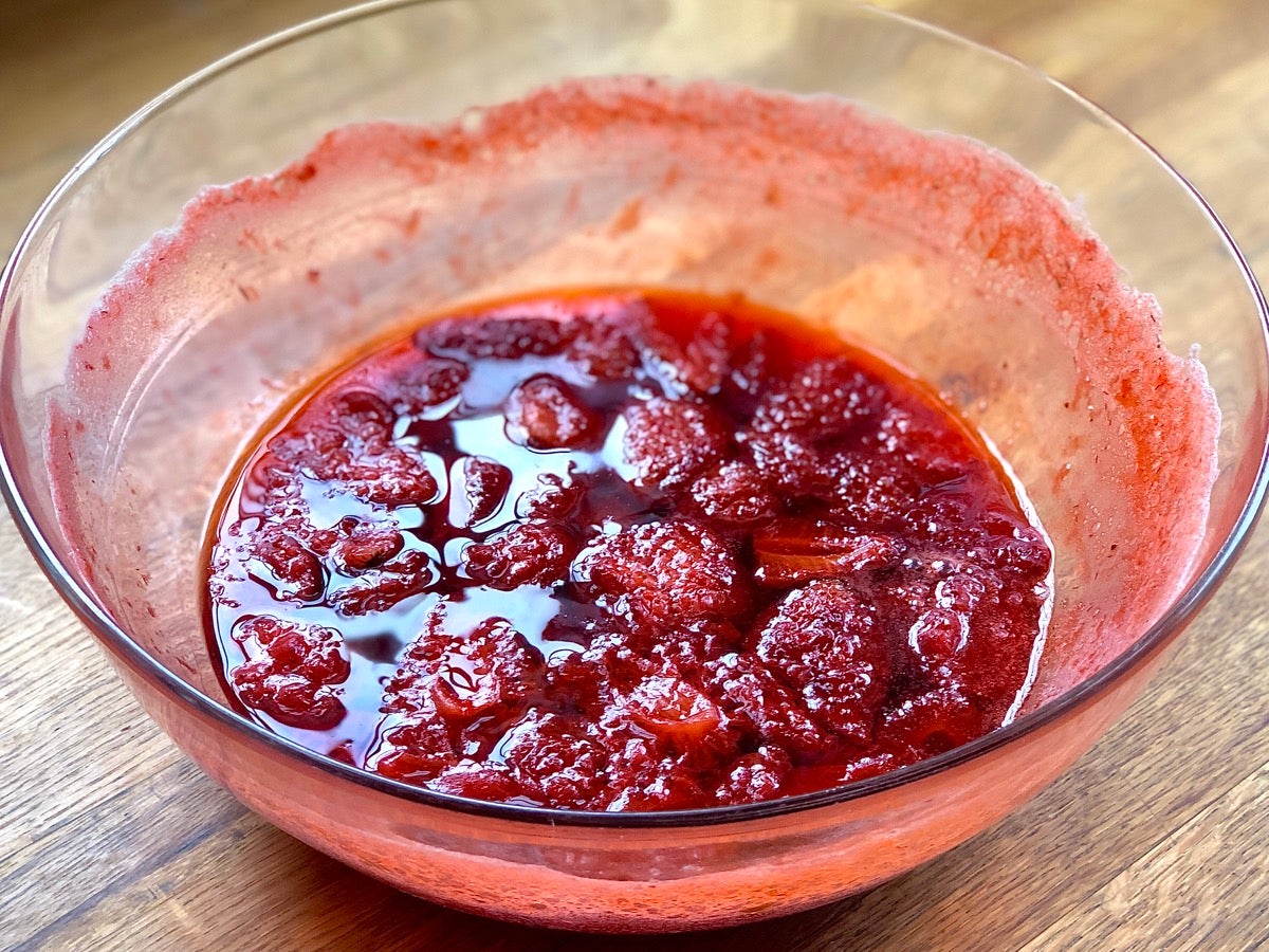 Bowl of partially cooked strawberry preserves.