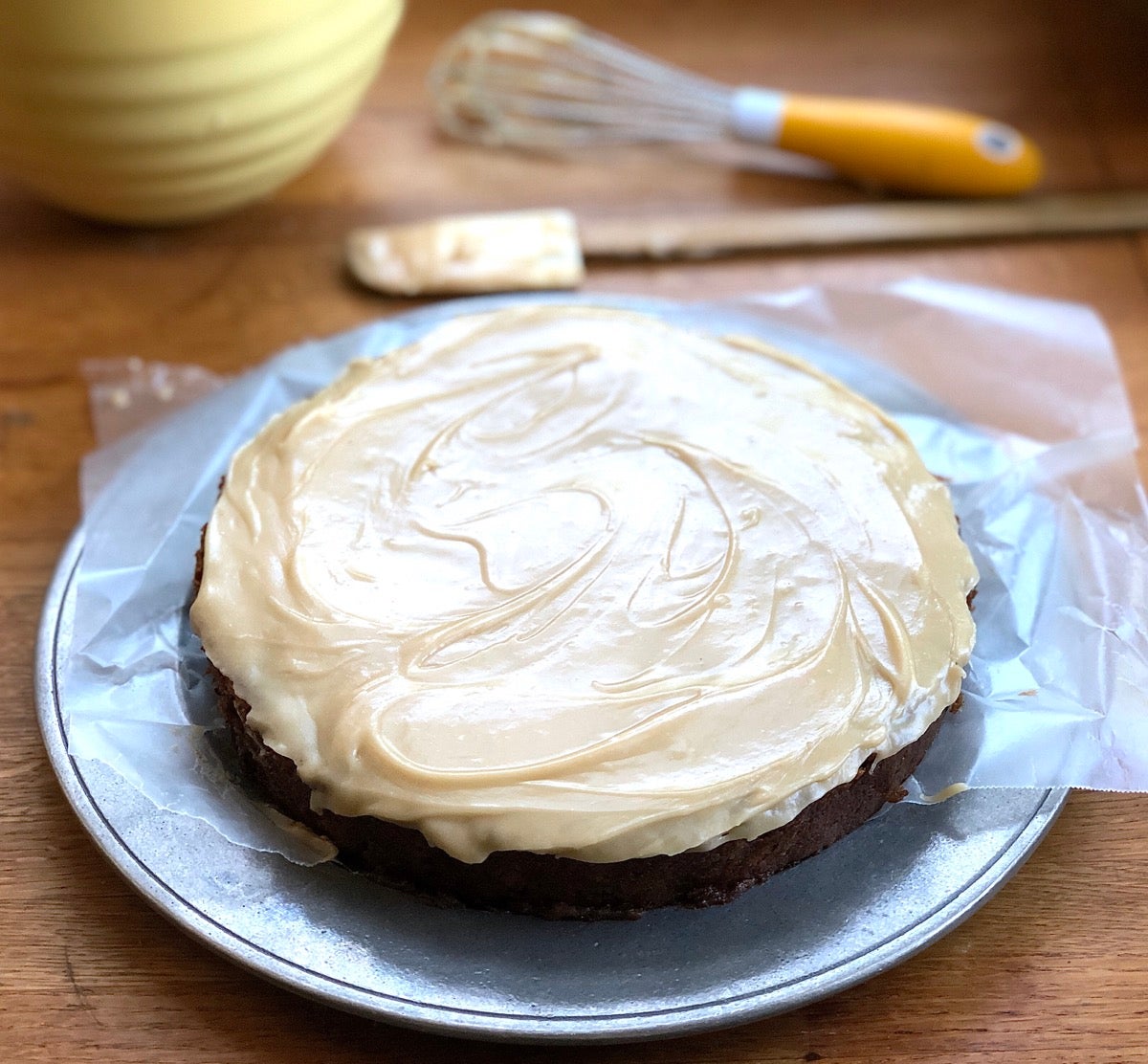 Apple cake baked in an 8" round pan and frosted with brown sugar frosting.