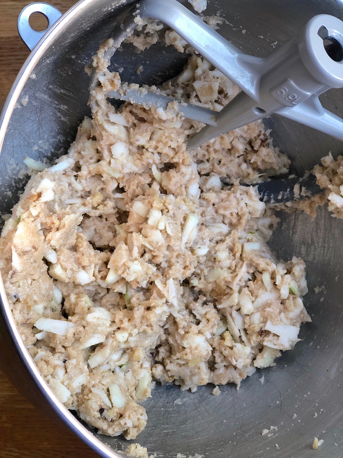 Apple cake ingredients being mixed in a mixing bowl.