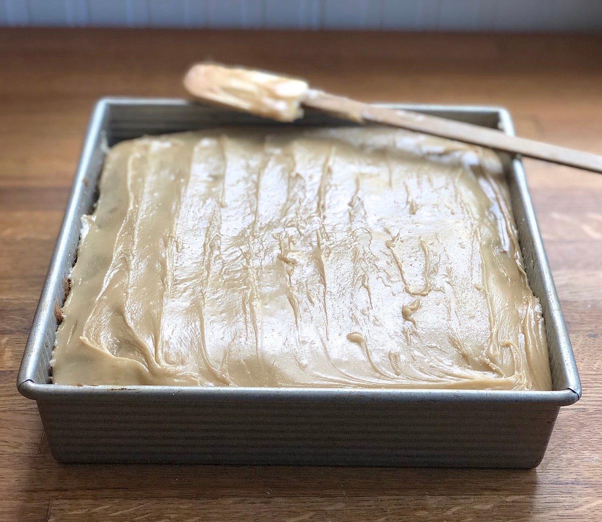 Frosted apple cake in a 9" x 13" pan.