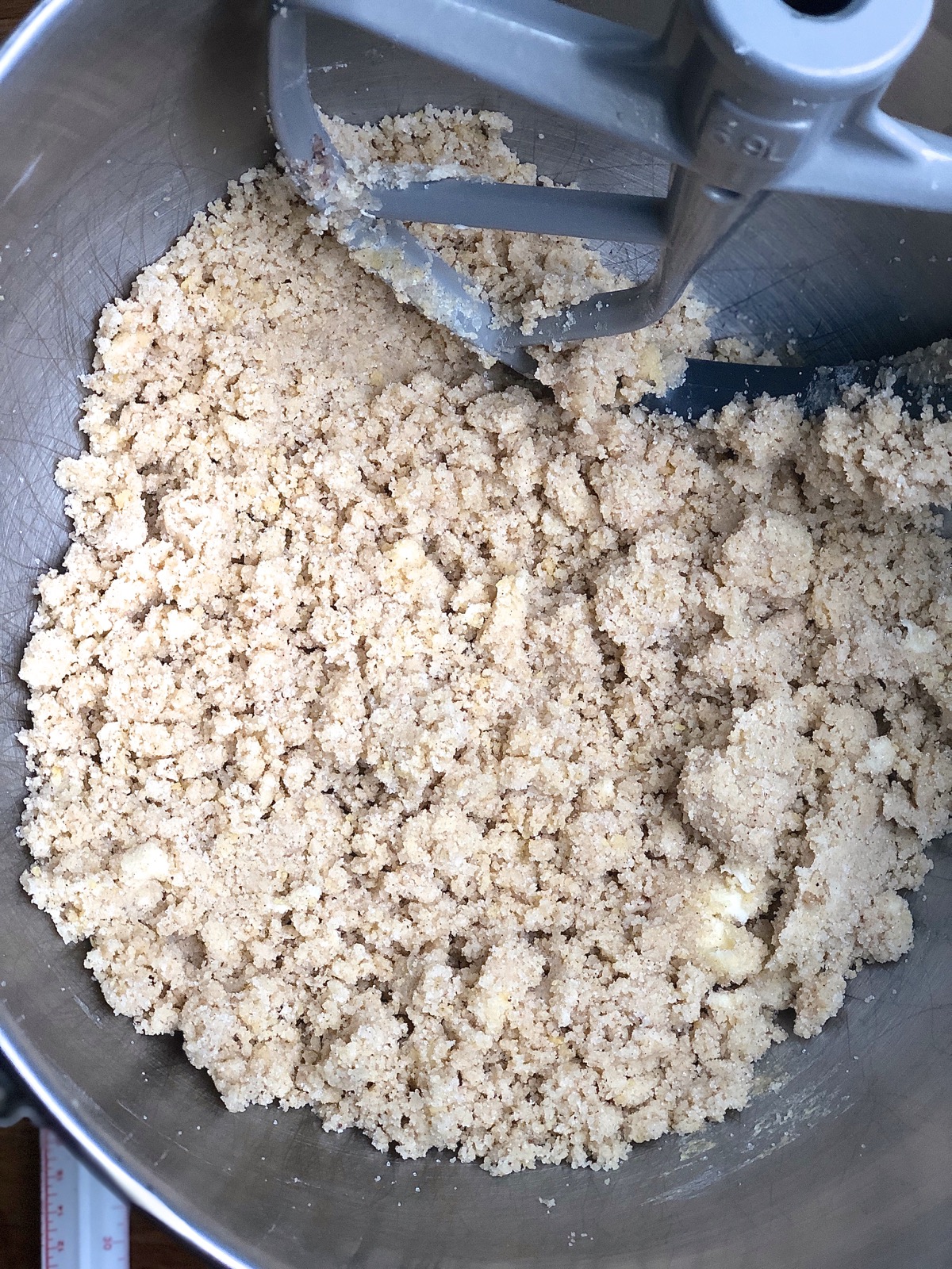 Some of the ingredients for apple cake mixed together in a bowl until crumbly.