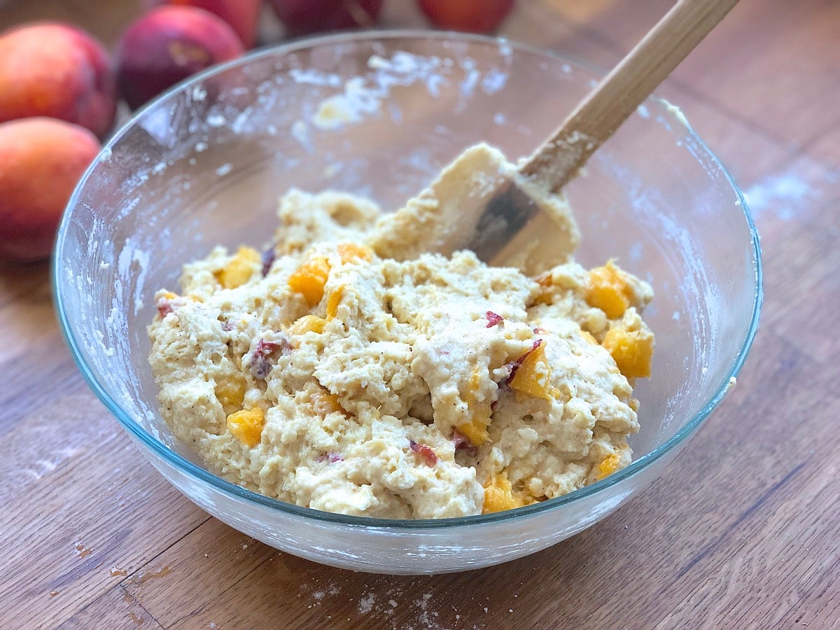 Sticky peach scone dough in a bowl, ready to be scooped into individual scones.