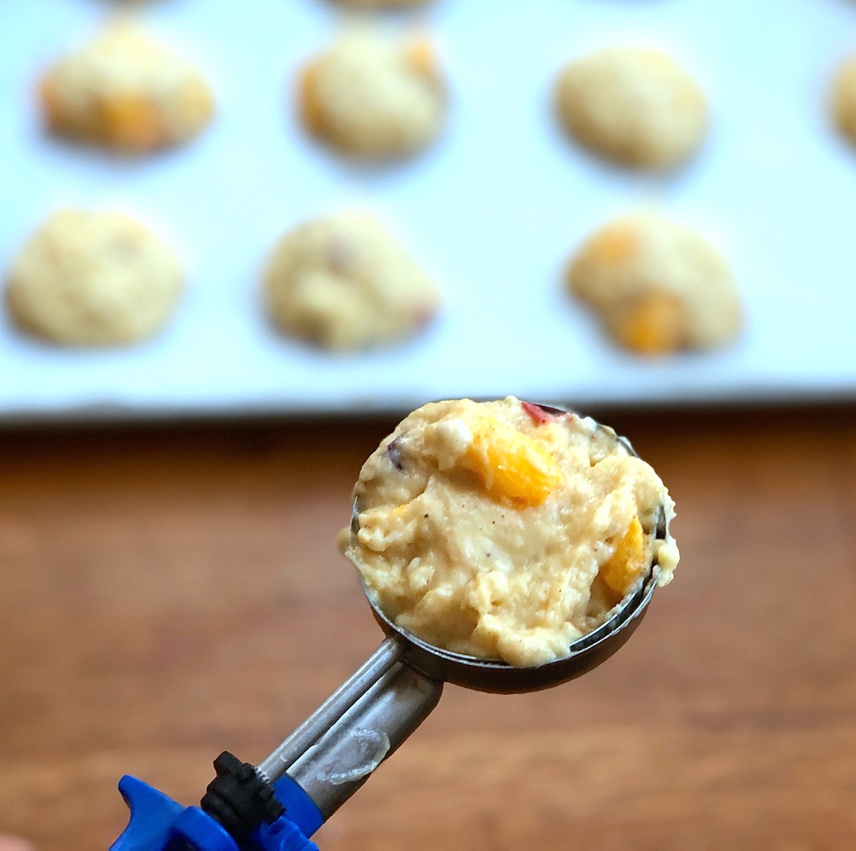Peach scone dough in a muffin scoop, ready to be dropped onto a baking sheet.