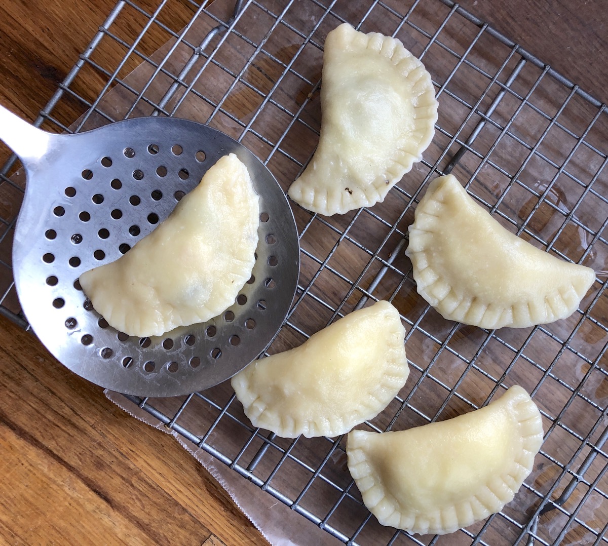 Cooked, drained pierogi on a cooling rack.