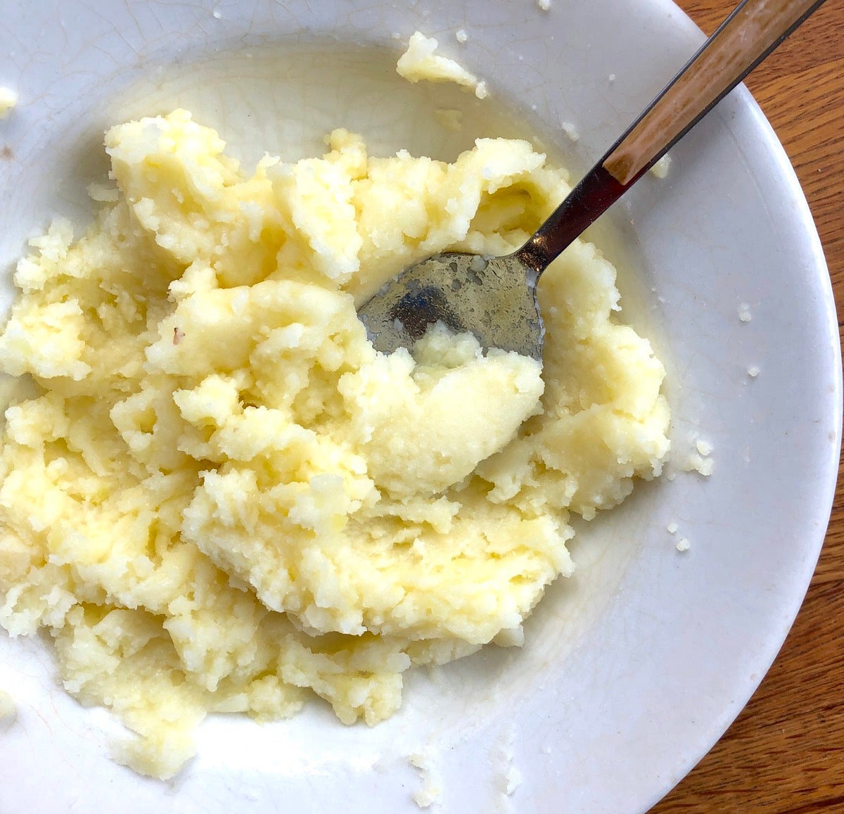 Mashed potato and cheddar cheese filling in a white bowl.