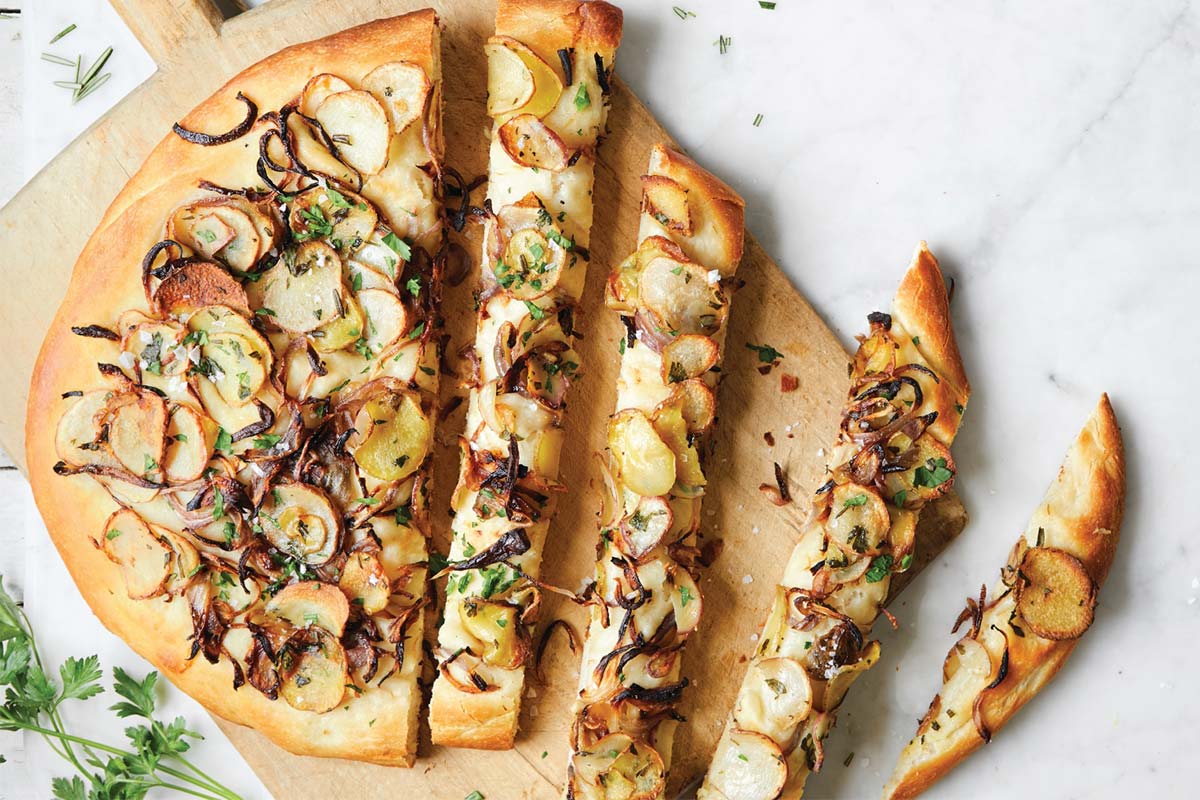 Baked potato focaccia topped with thinly sliced potatoes and herbs
