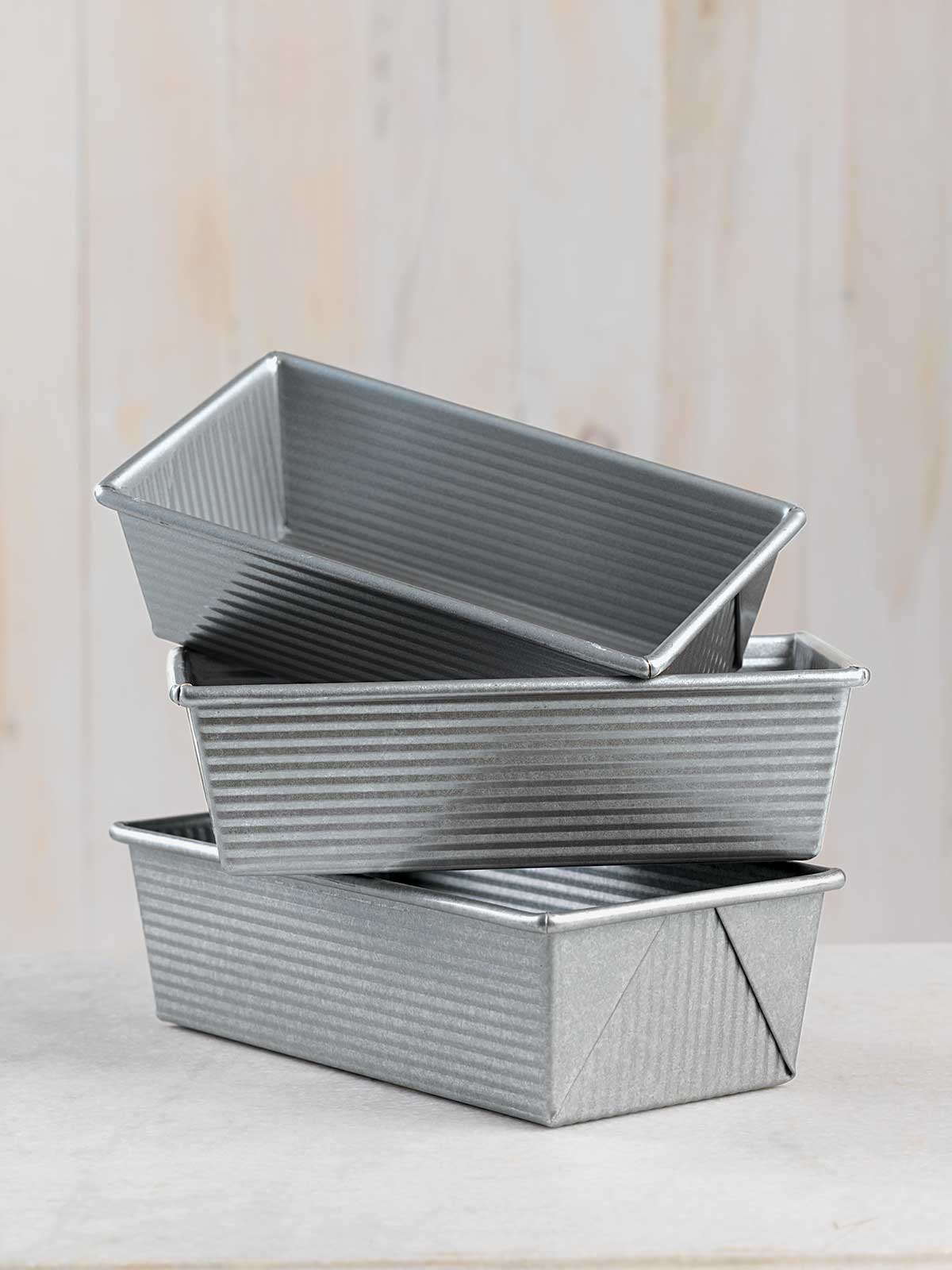 A stack of loaf pans on a kitchen table