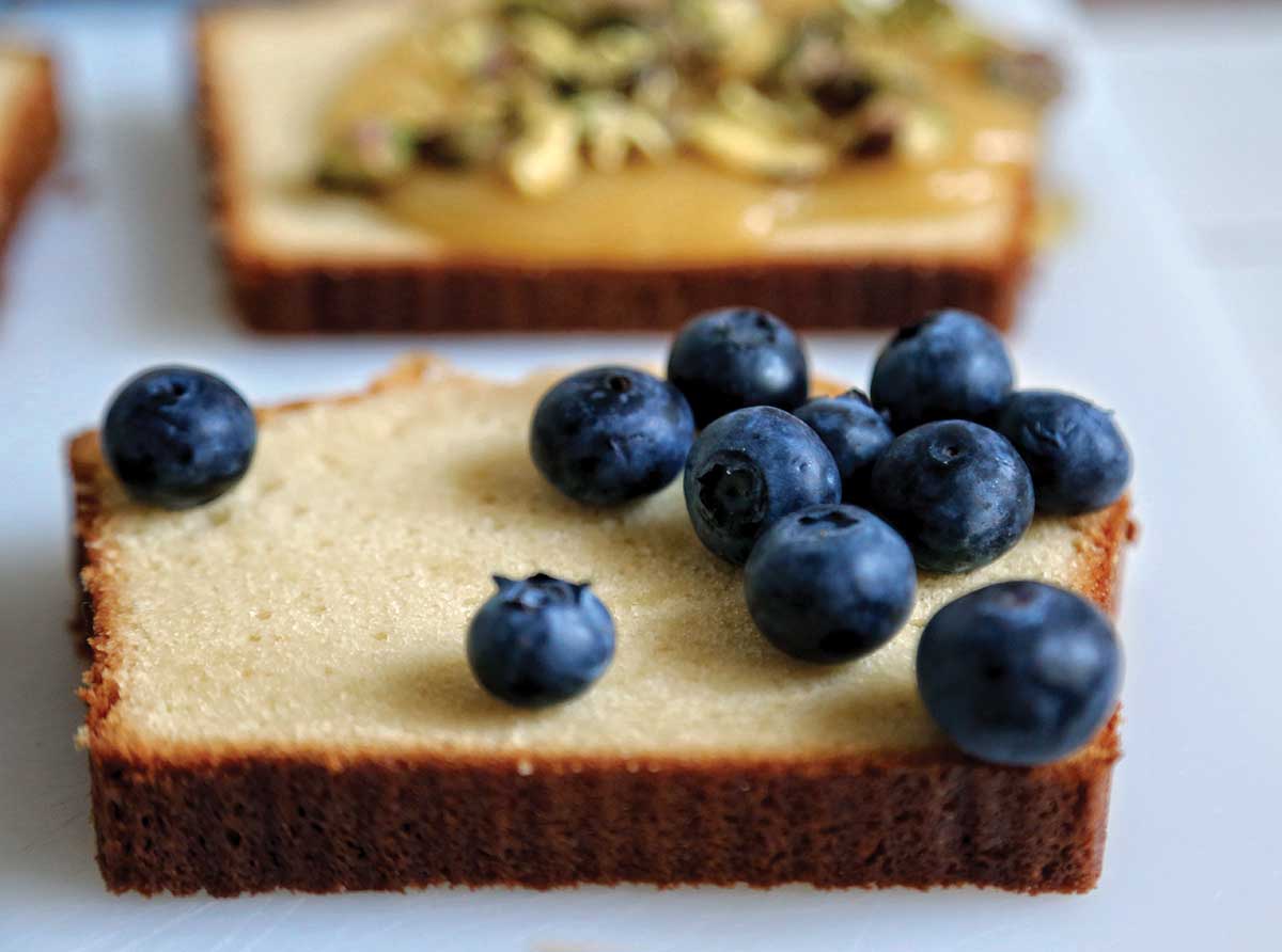 A slice of pound cake topped with fresh blueberries