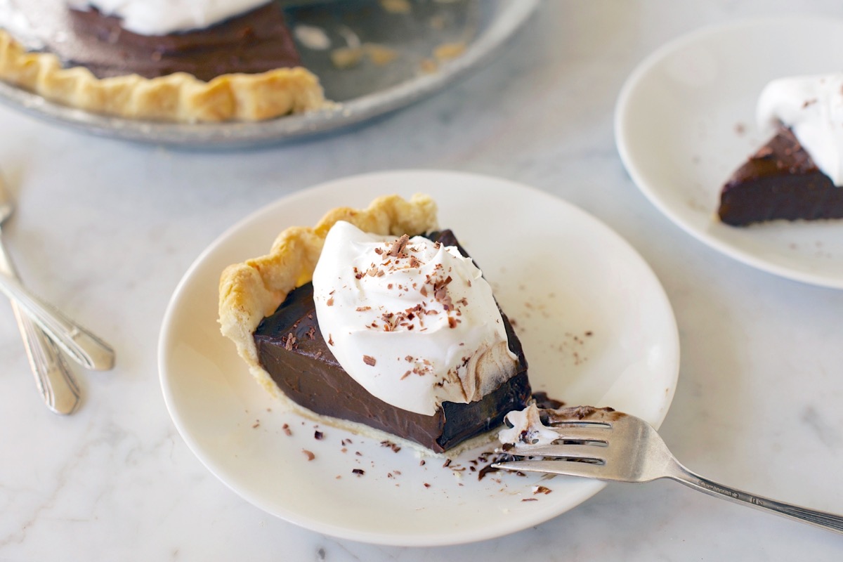 Slice of chocolate cream pie on a plate garnished with whipped cream