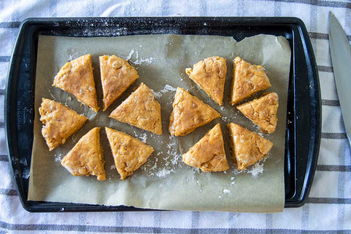 Scone dough rounds cut into wedges on baking sheet