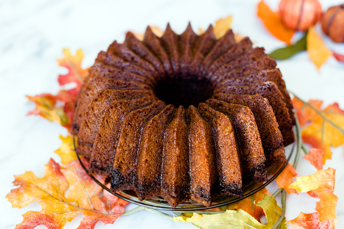 A pumpkin Bundt cake sitting on a table in a fall setting