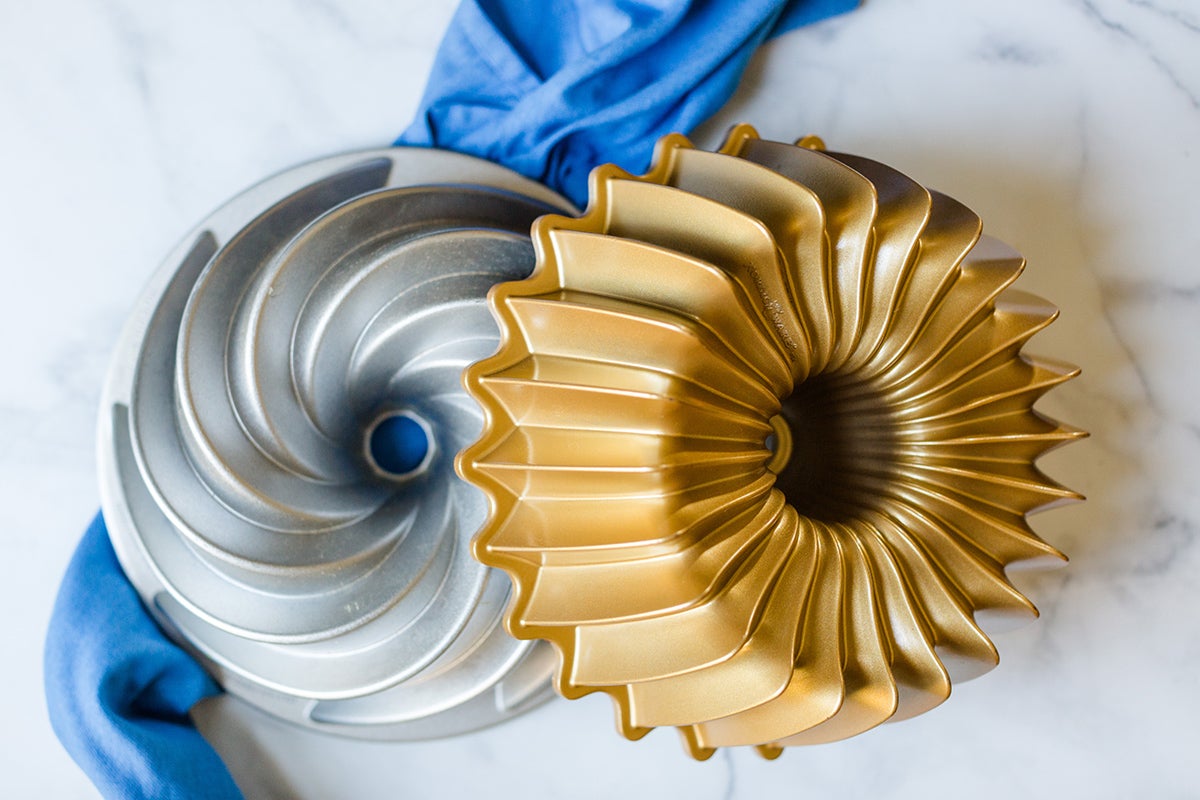 A swirl Bundt pan and brillant Bundt pan sitting on a kitchen table