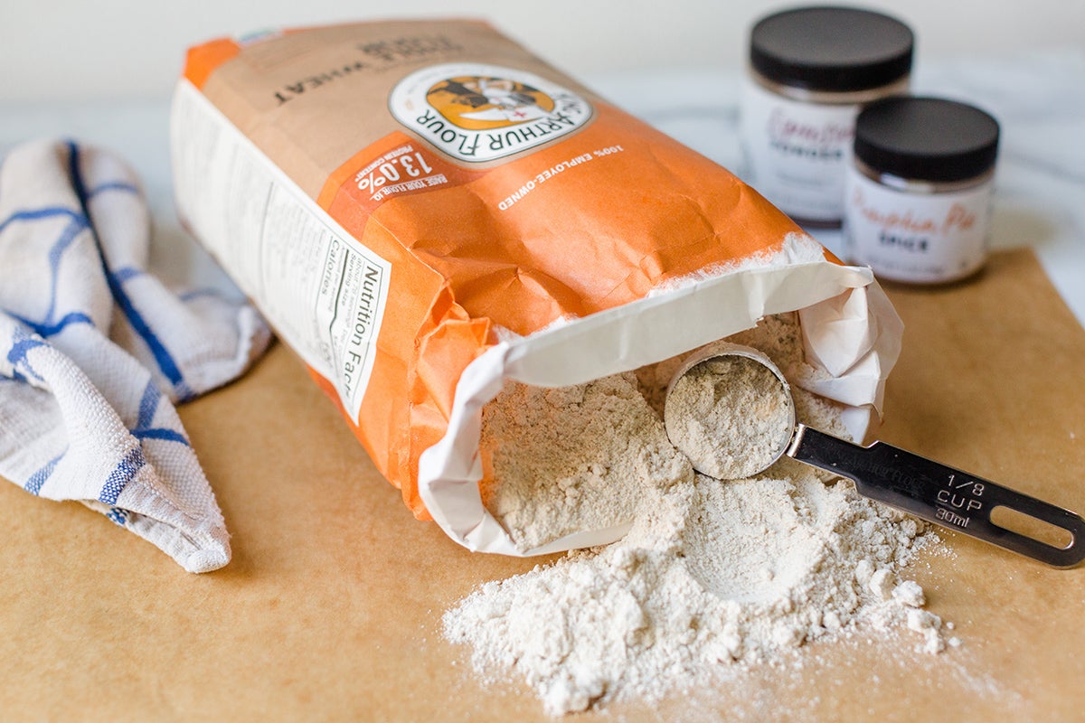 A bag of white whole wheat flour with some in a measuring cup