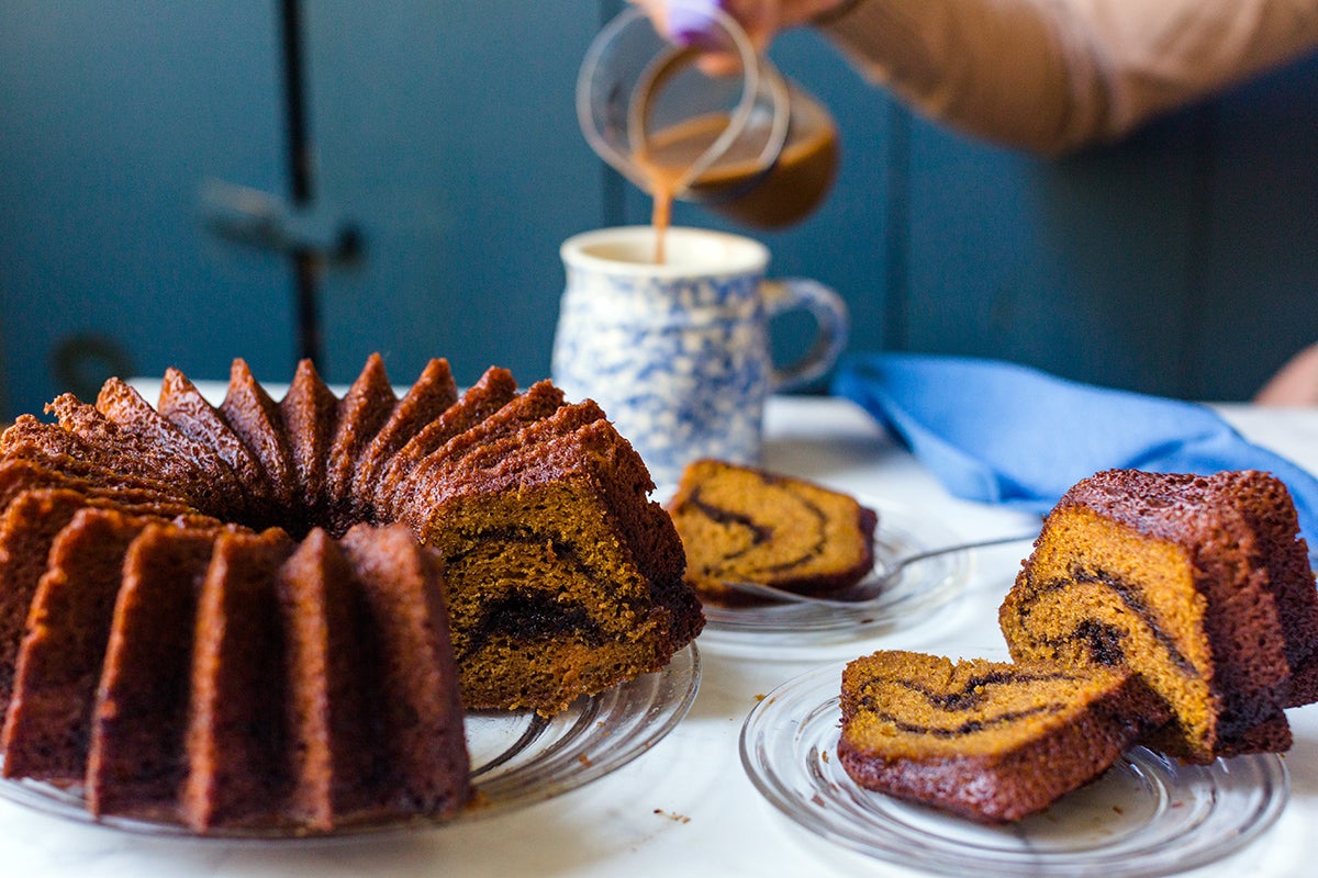 A person pouring coffee into a mug next to slices of Pumpkin Espresso Bundt Cake