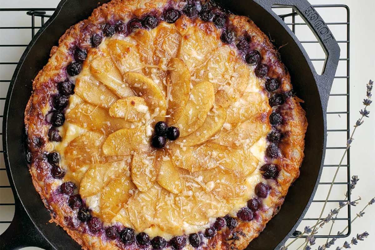 Pizza in cast iron skilled with circular design made of fruit toppings