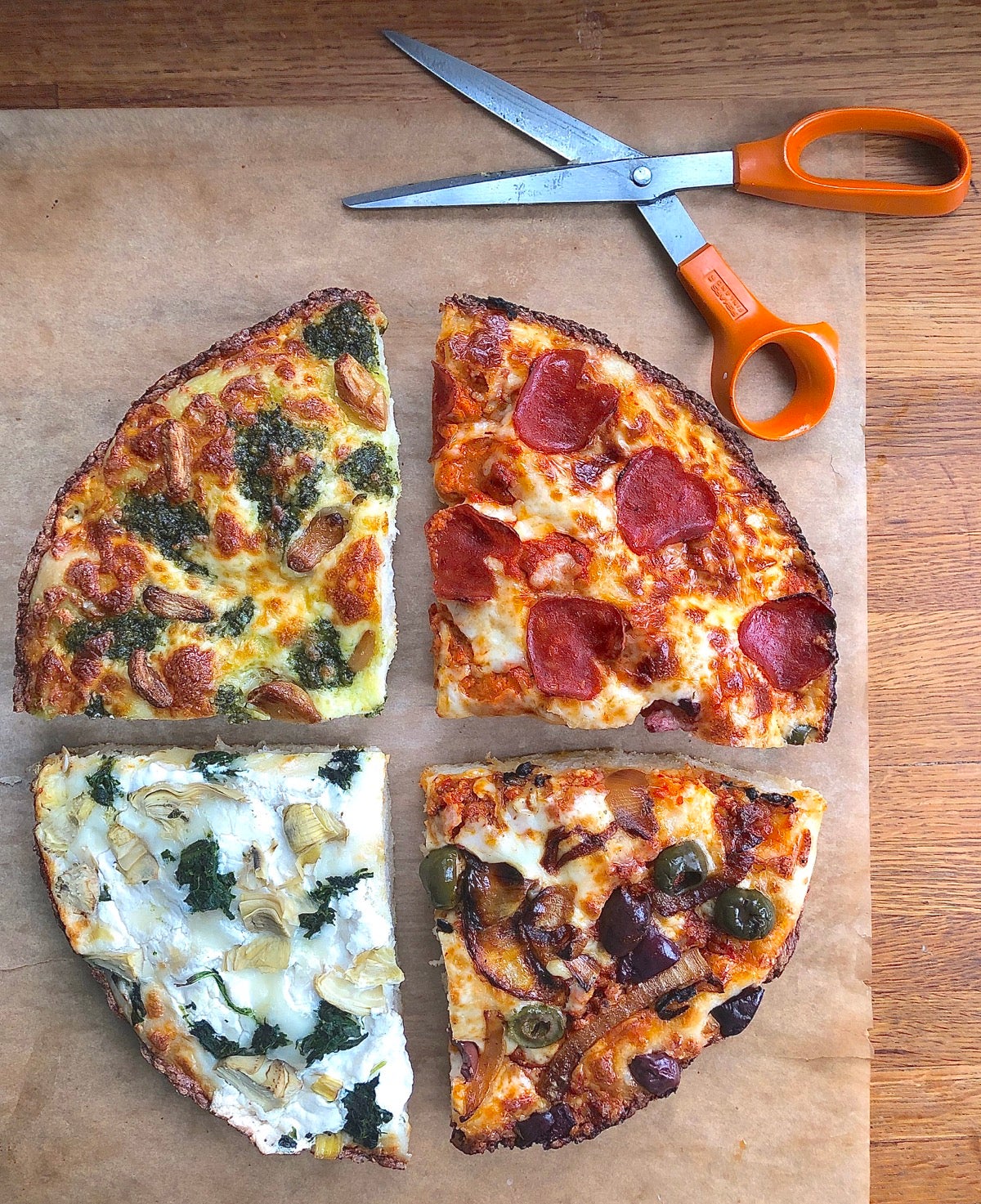 Four quarters of pizza, each with different sauces and toppings, arranged in a circle.