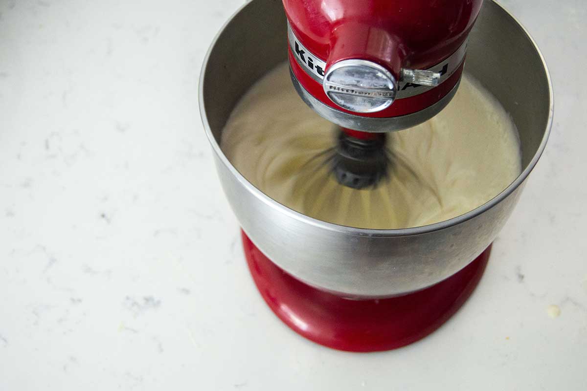 Stand mixer with whisk beating thick batter in bowl
