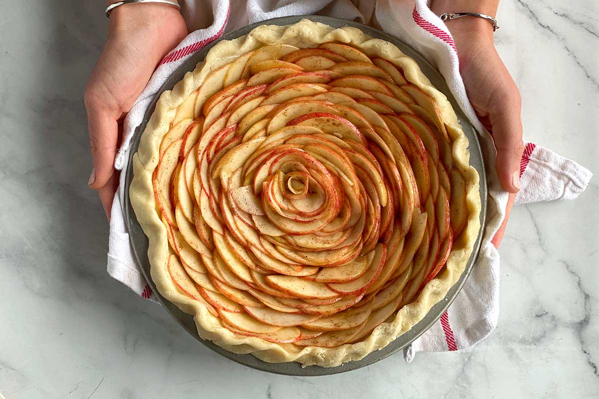 An unbaked rose apple pie on a kitchen table, ready to go in the oven