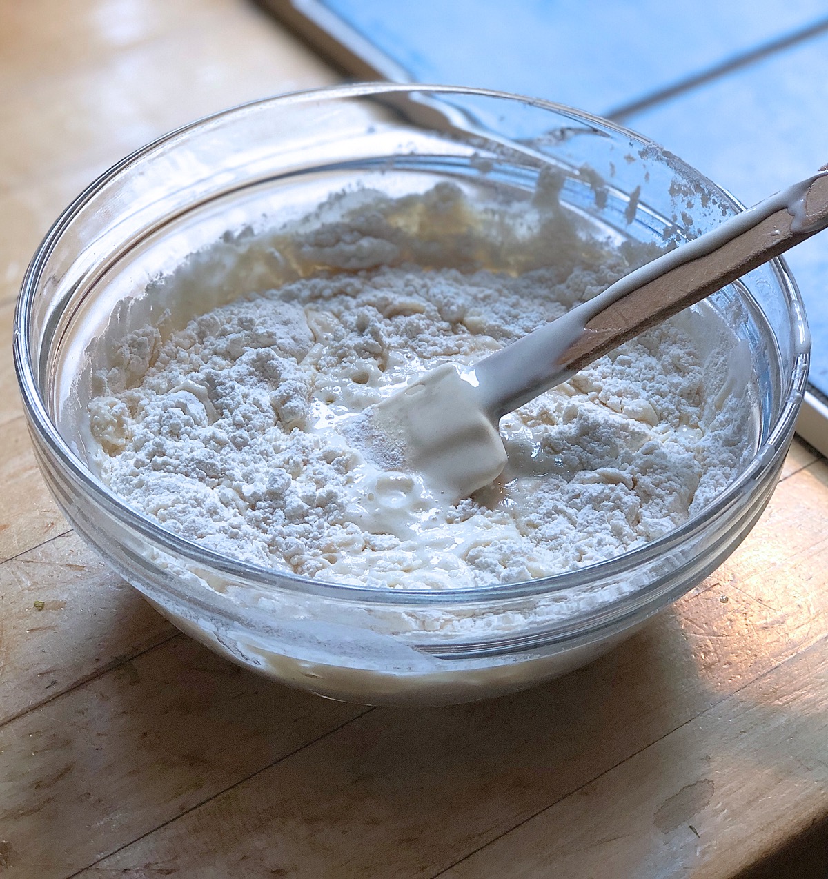 Sourdough starter in a bowl with flour and water, ready to be stirred together.