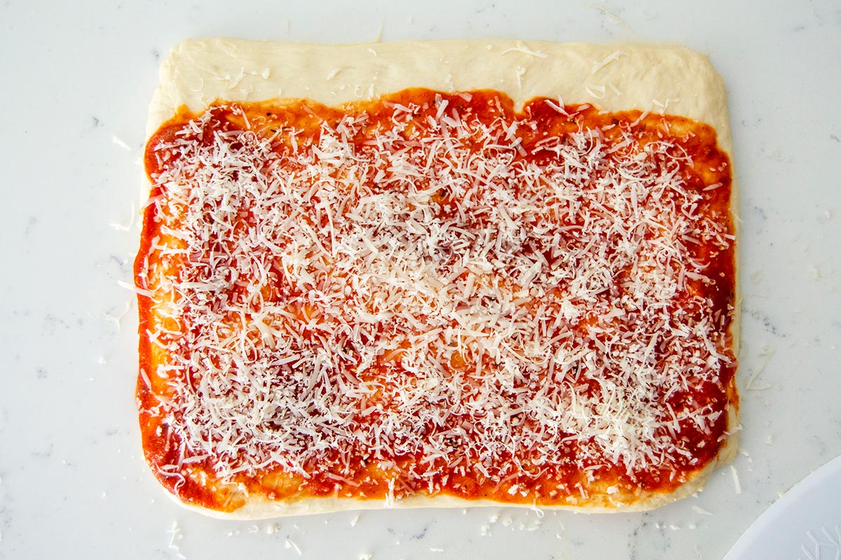 Rolled out dough with tomato sauce and cheese